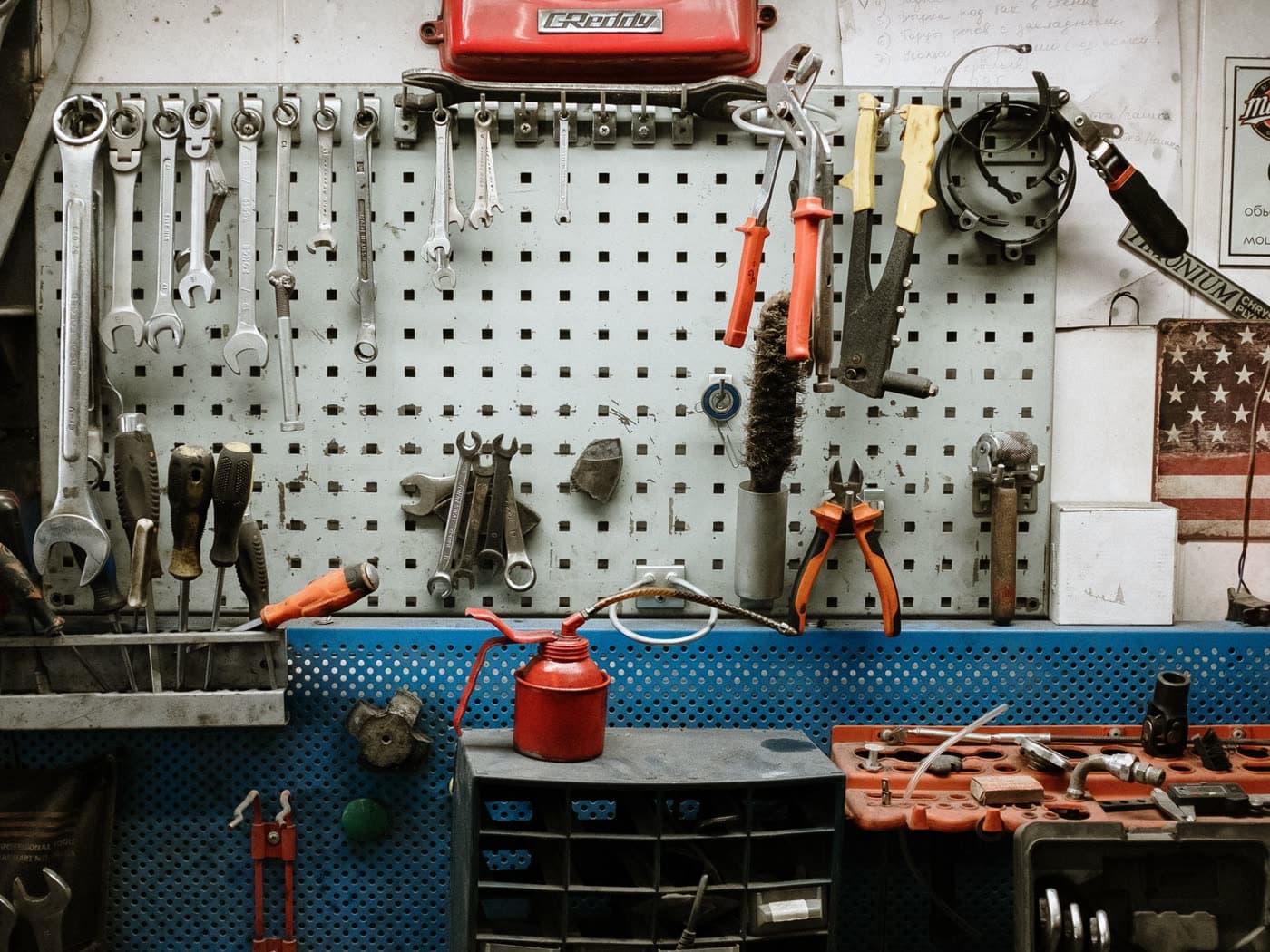 A workshop pegboard hung with wrenches, pliers and hand tools