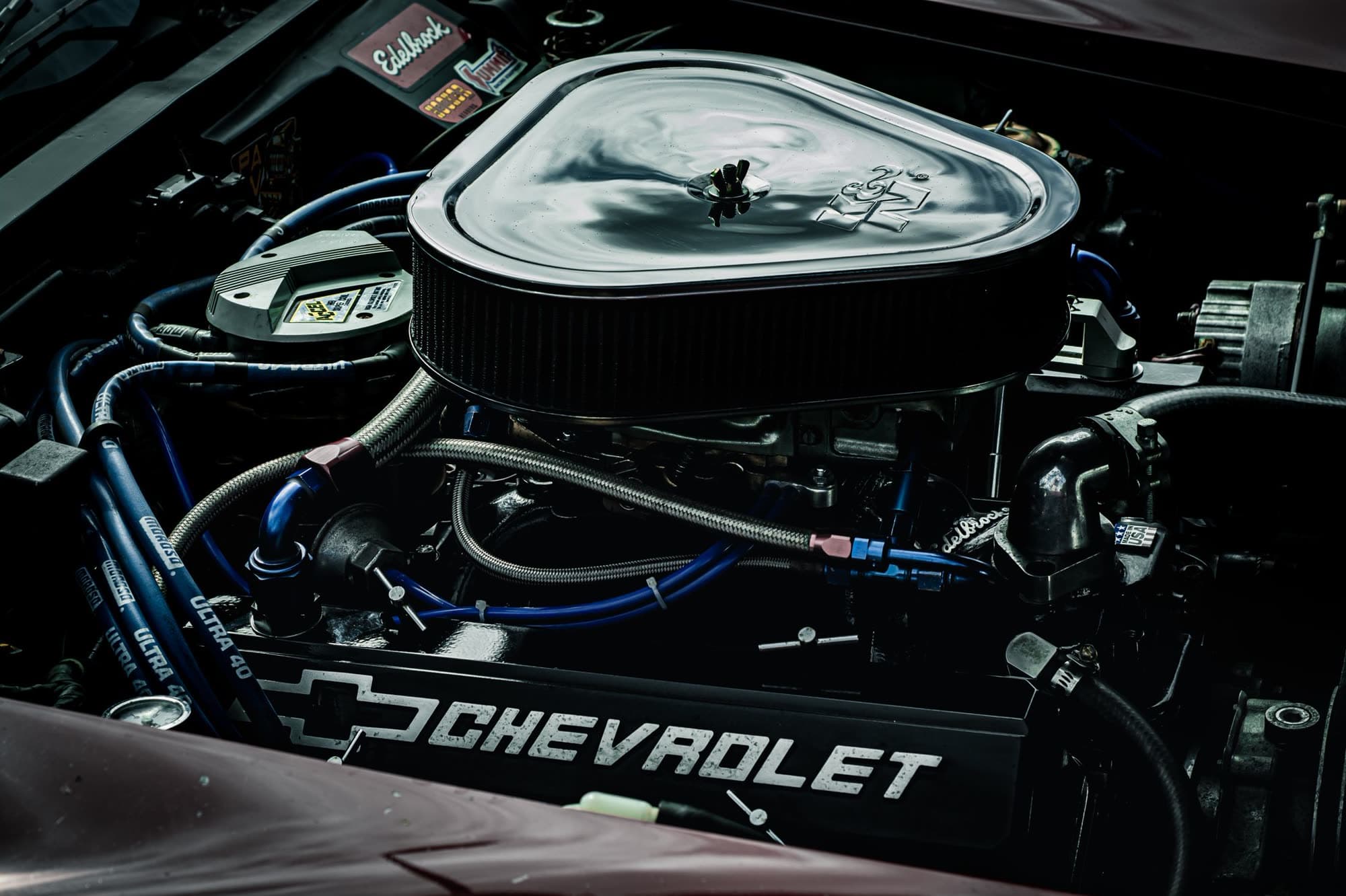 A chrome-topped American V8 under an open hood