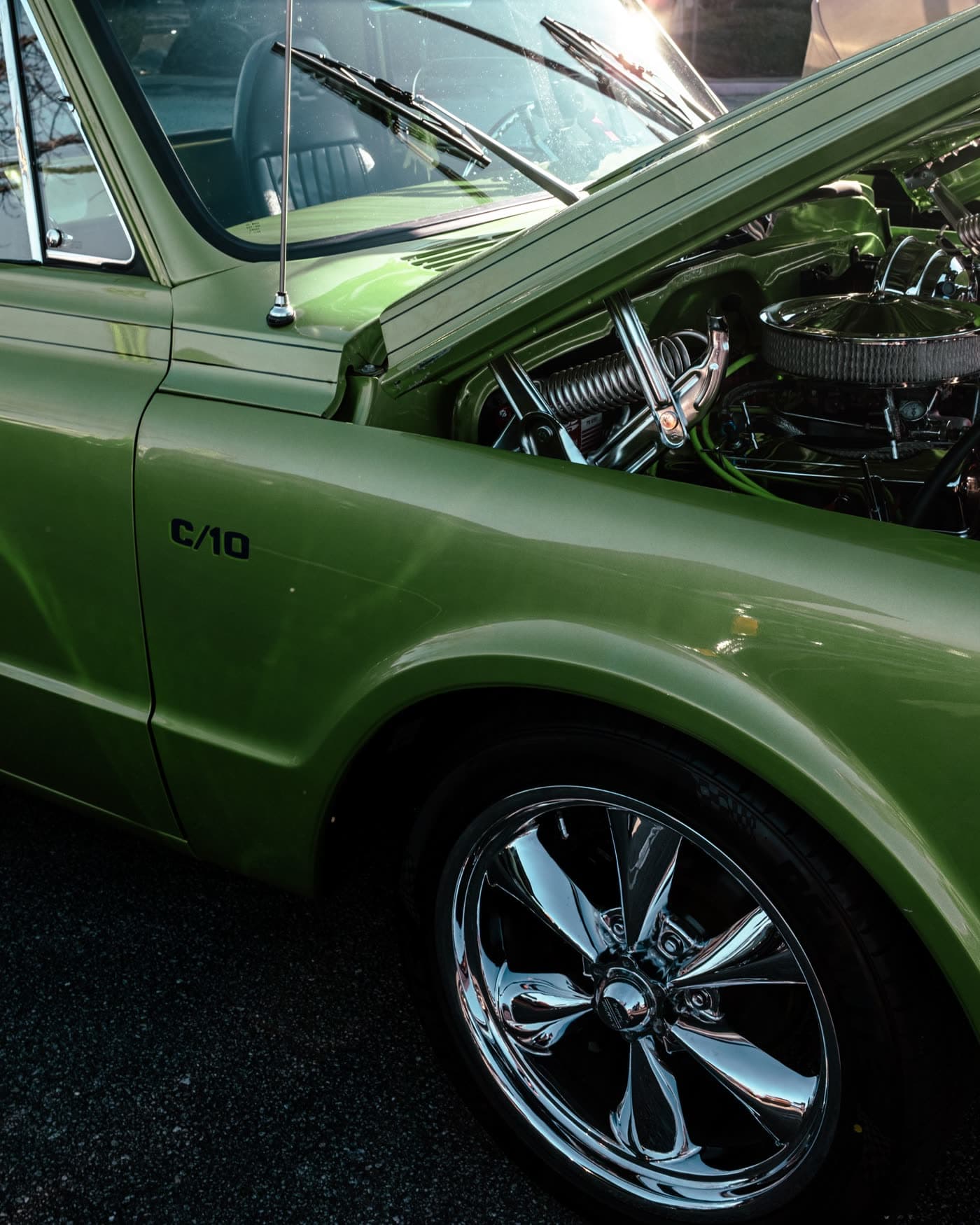 An American pickup parked outside with its hood up, being worked on where it sits